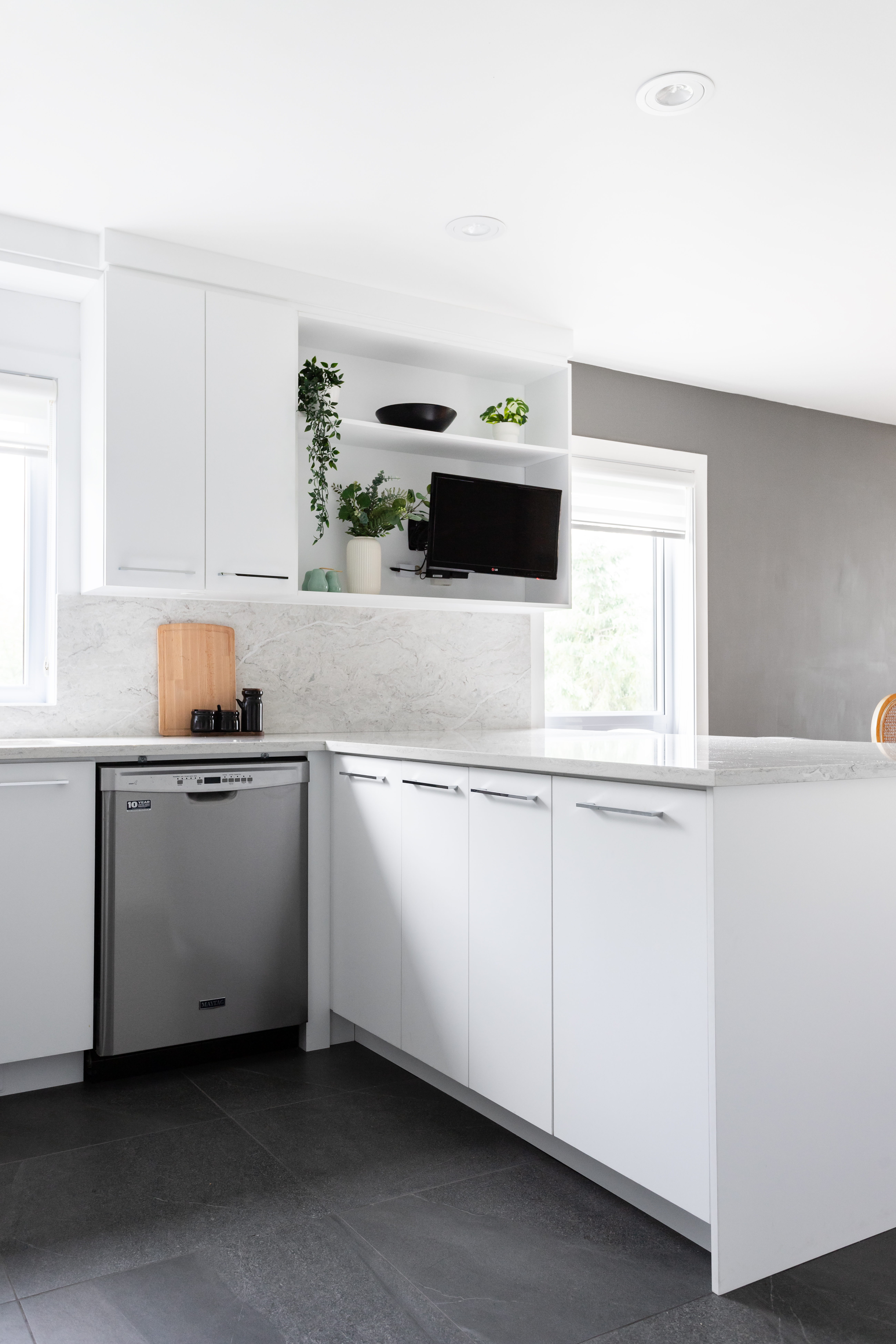 Magnifique cuisine moderne blanche polymère avec des comptoirs et dosseret en quartz.