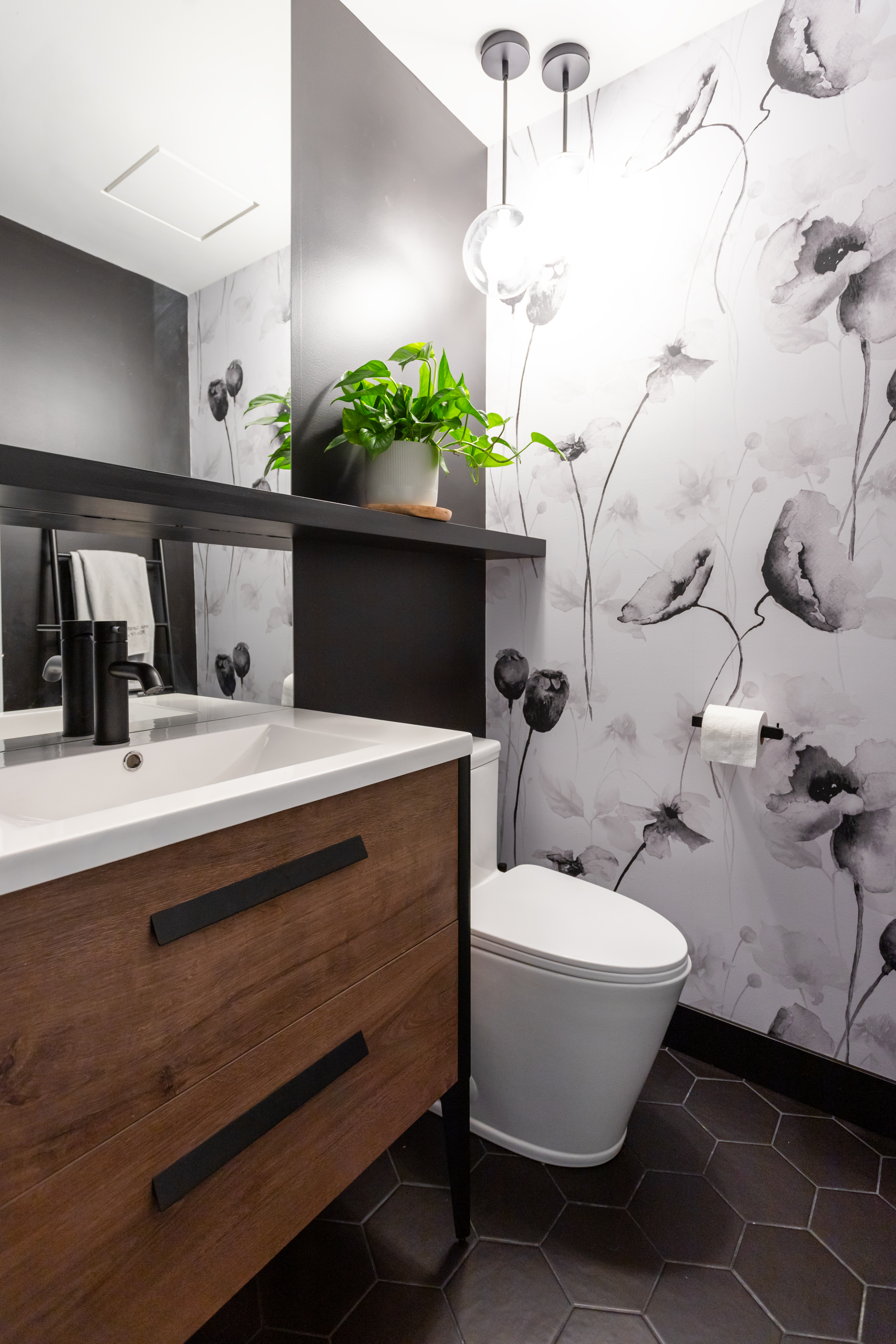 Magnifique salle d'eau avec luminaires suspendu, murale papier peint autocollant fleuris, contraste de blanc et noir avec vanité préfabriqué effet bois