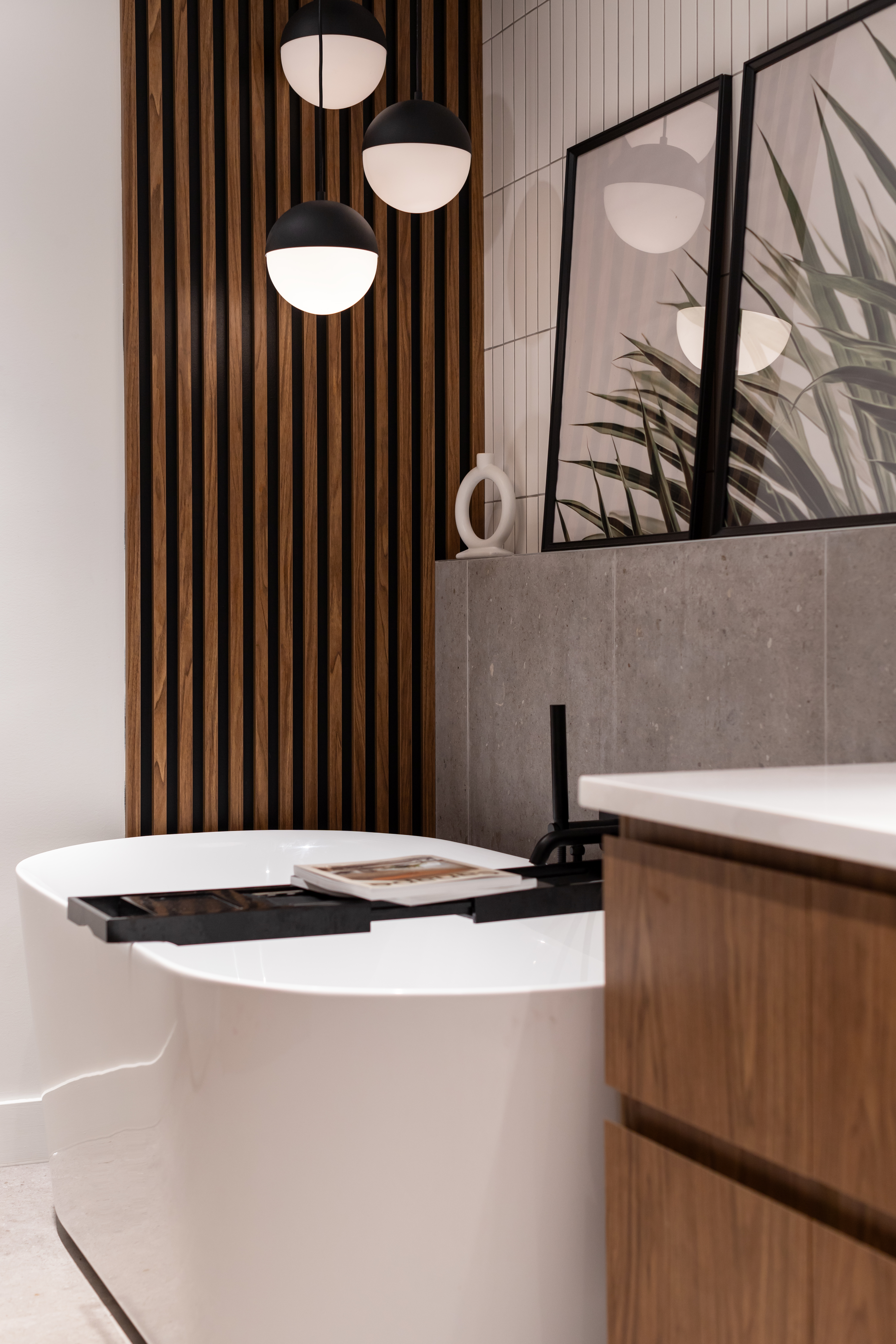 rénovation salle de bain, style moderne organique, effet béton, avec du blanc et de l'effet bois. Lattes de bois ou le bain. Bain autoportant. Vanité sur mesure autoportante