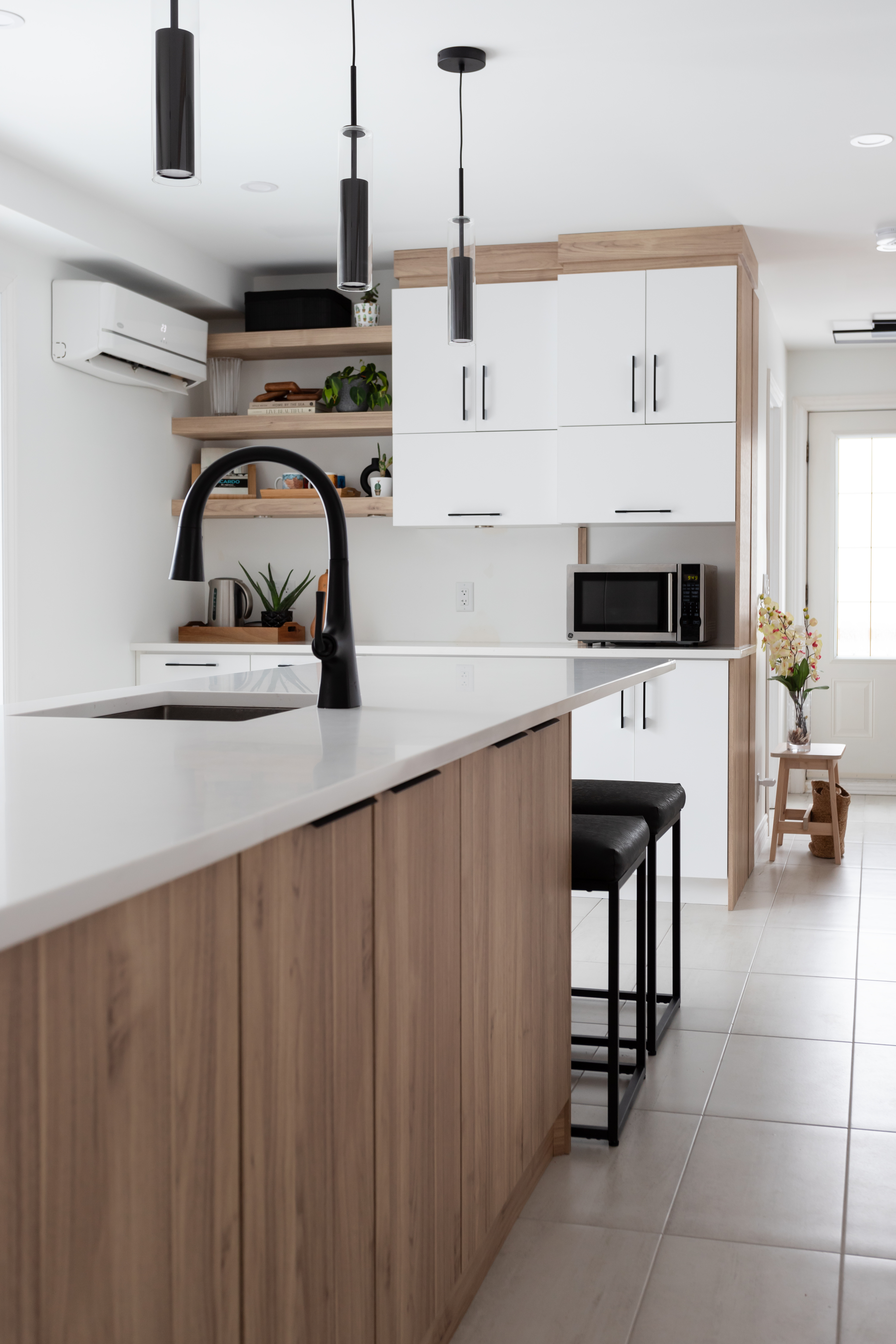 Magnifique cuisine contemporaine avec des armoire en polyester blanche & effet bois avec un comptoir en quartz. 