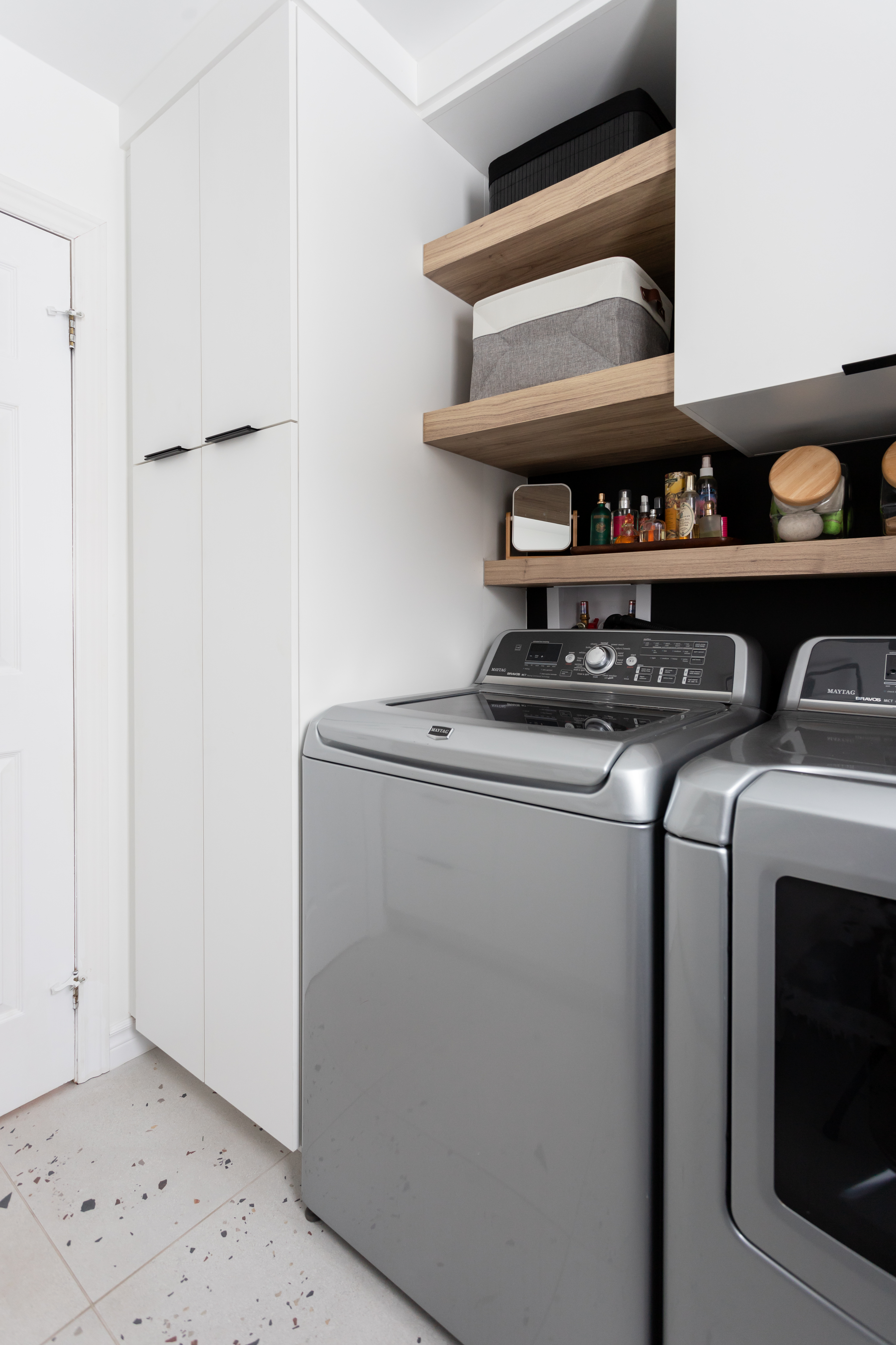 Une salle de lavage magnifique avec son plancher de porcelaine effet terrazzo, ou le rangement est optimisée & fonctionnel. Elle rend les tâches du quotidien plus attrayantes.