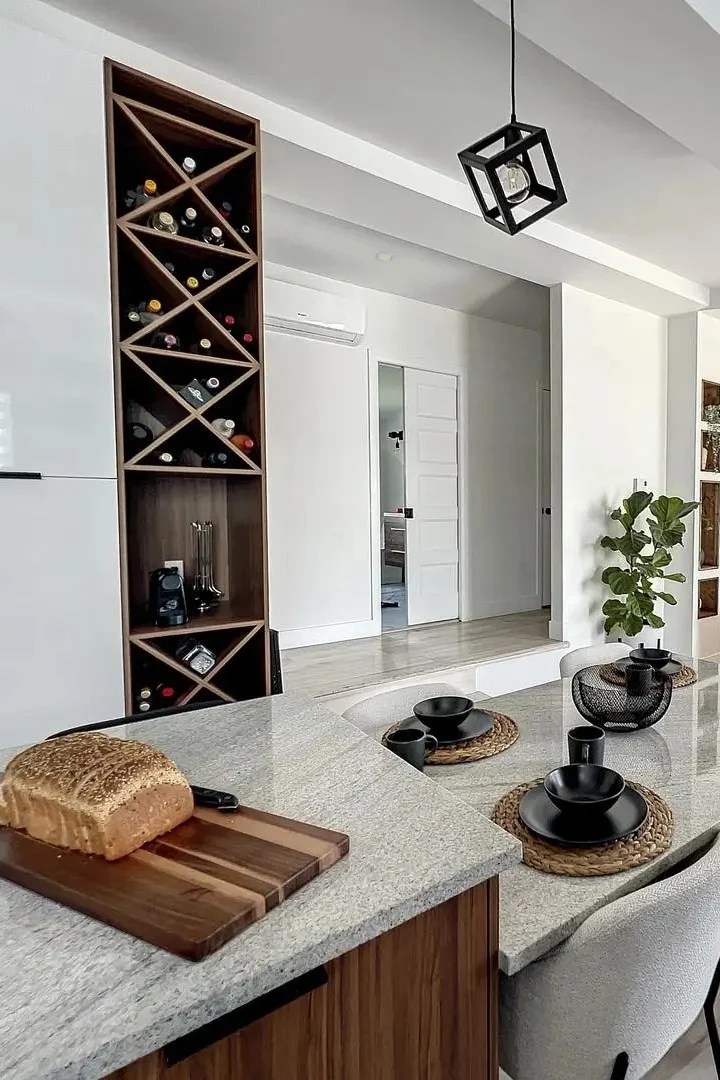 Plaque de cuisson et hotte rétractable intégrées dans l'ilot de la rénovation complète du rez-de-chaussée d'une maison à Québec par élévation studio design, elevation studio design