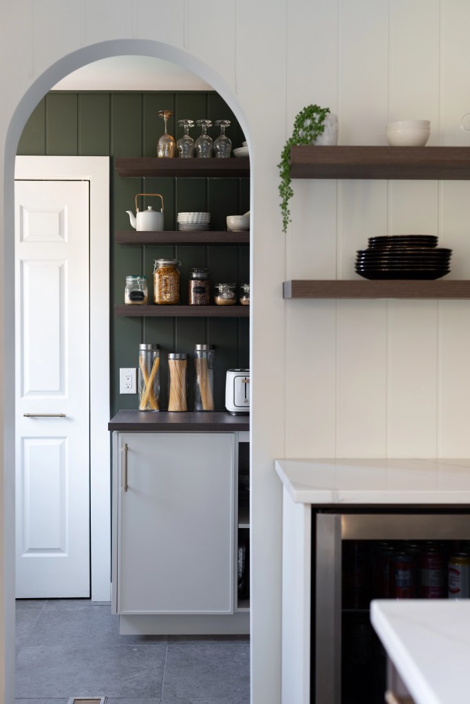 Garde-manger walk-in avec étagères ouvertes et rangement organisé, tablettes flottantes effet bois, shiplap peint vert. Projet Savard Landry, rénovation rez-de-chaussée, cuisine, pantry, back-kitchen, garde-manger walk-in, à Bécancour, Trois-Rivières, par les meilleures designers d'intérieur, Élévation Studio Design.