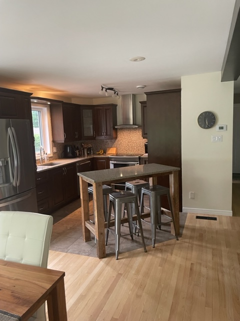 Rénovation de cuisine greige avec porte shaker slim avec accents bois, comptoir de quartz pâle et accent doré. Design intemporel et chaleureux à Bécancour, Trois-Rivières, Québec, par Élévation Studio Design.