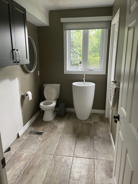 Rénovation de cuisine greige avec porte shaker slim avec accents bois, comptoir de quartz pâle et accent doré. Design intemporel et chaleureux à Bécancour, Trois-Rivières, Québec, par Élévation Studio Design.