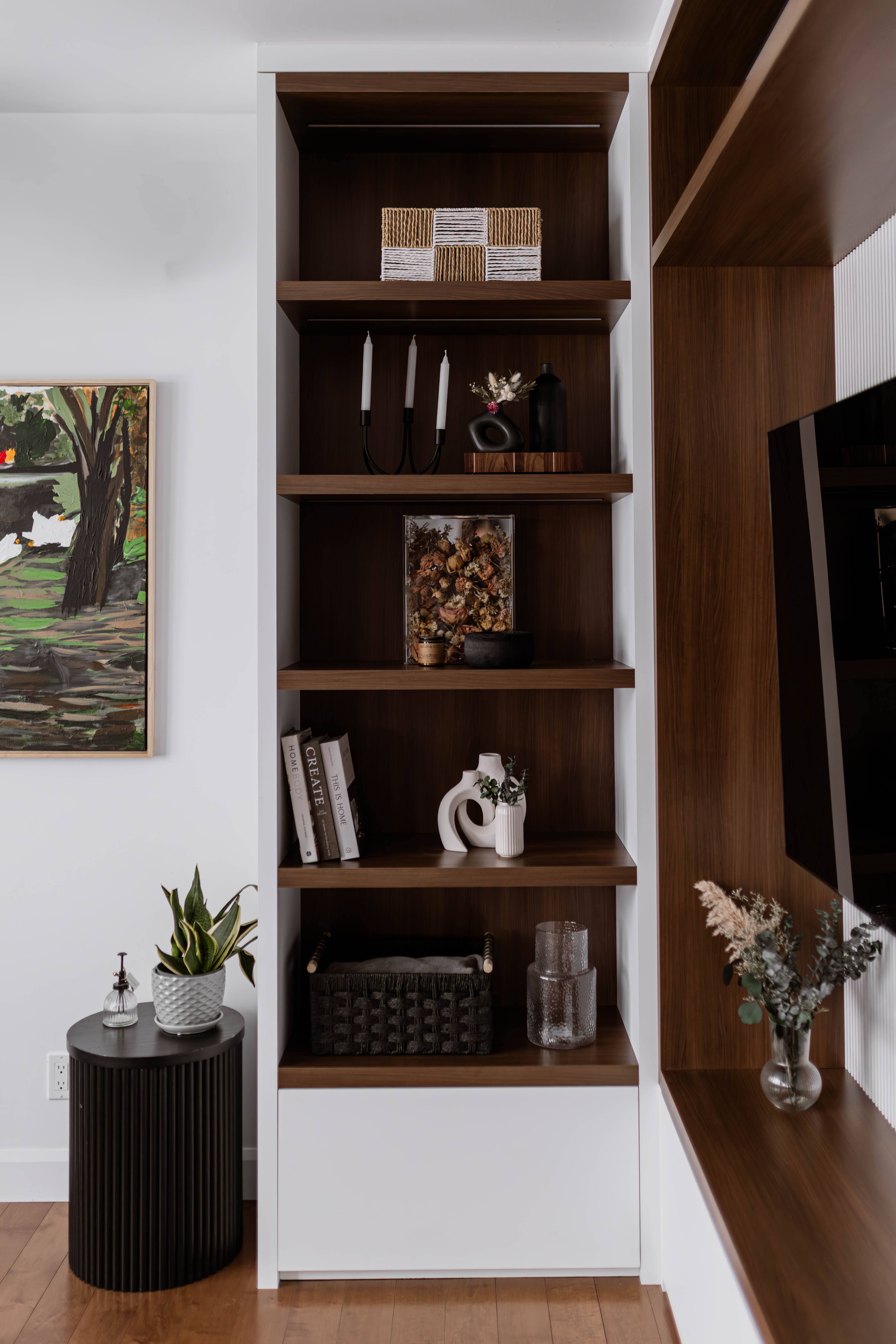 Salon chaleureux et intemporel avec armoires de bois et rangements sur mesure. Projet Jodoin Caplette, Drummondville, par Élévation Studio Design.