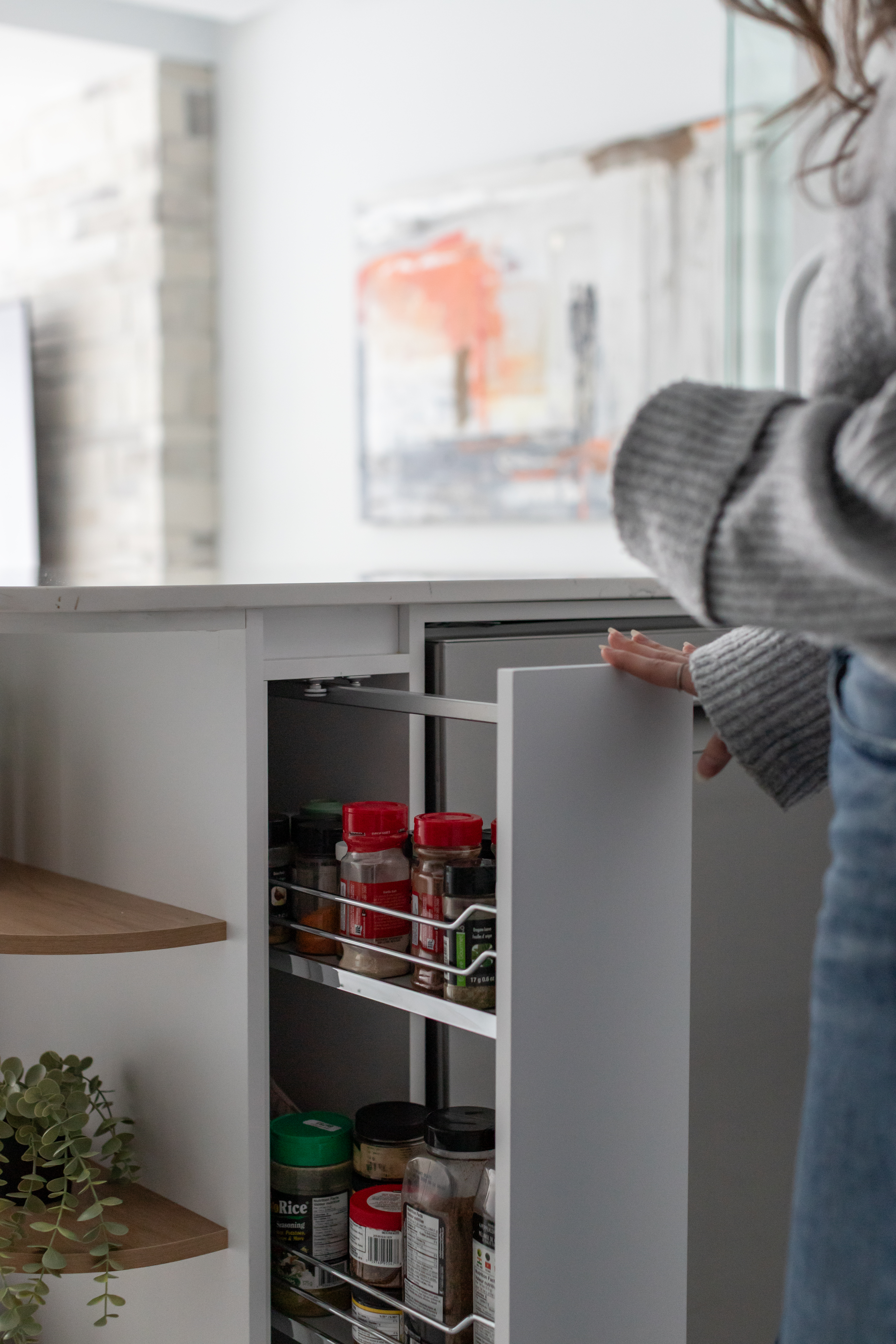 Rangements de cuisine sur mesure optimisant l’espace dans un projet de rénovation de condo | tirette pour le rangement à épices et huiles | designer d'intérieur et cuisiniste, Élévation Studio Design à Thetford Mines