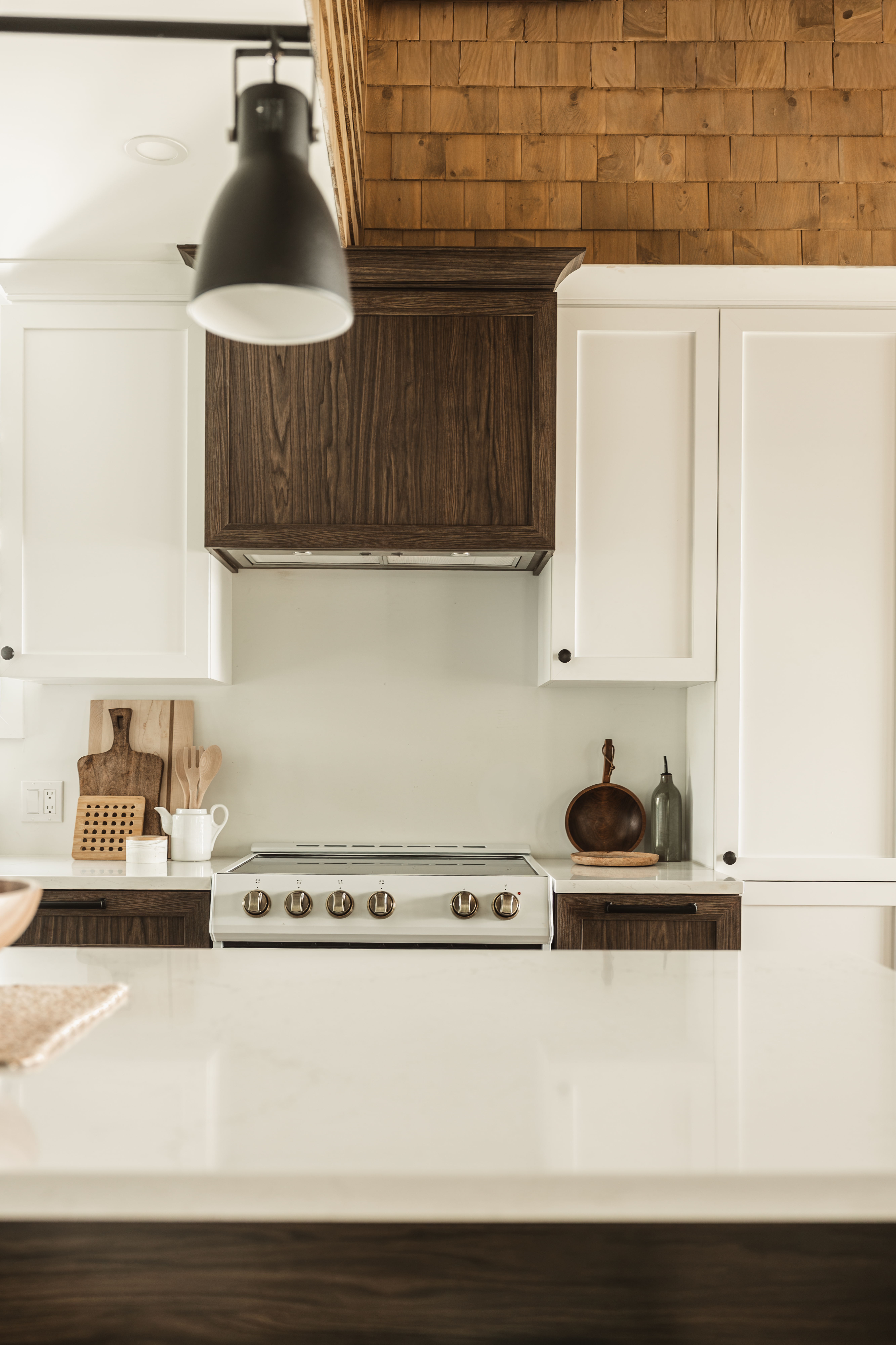 Cuisine sur mesure rénovée avec hotte en bois foncé, de style farmhouse. Chalet au bord de l'eau à Disraeli. Service de staging pour faire la décoration à la fin des rénovations