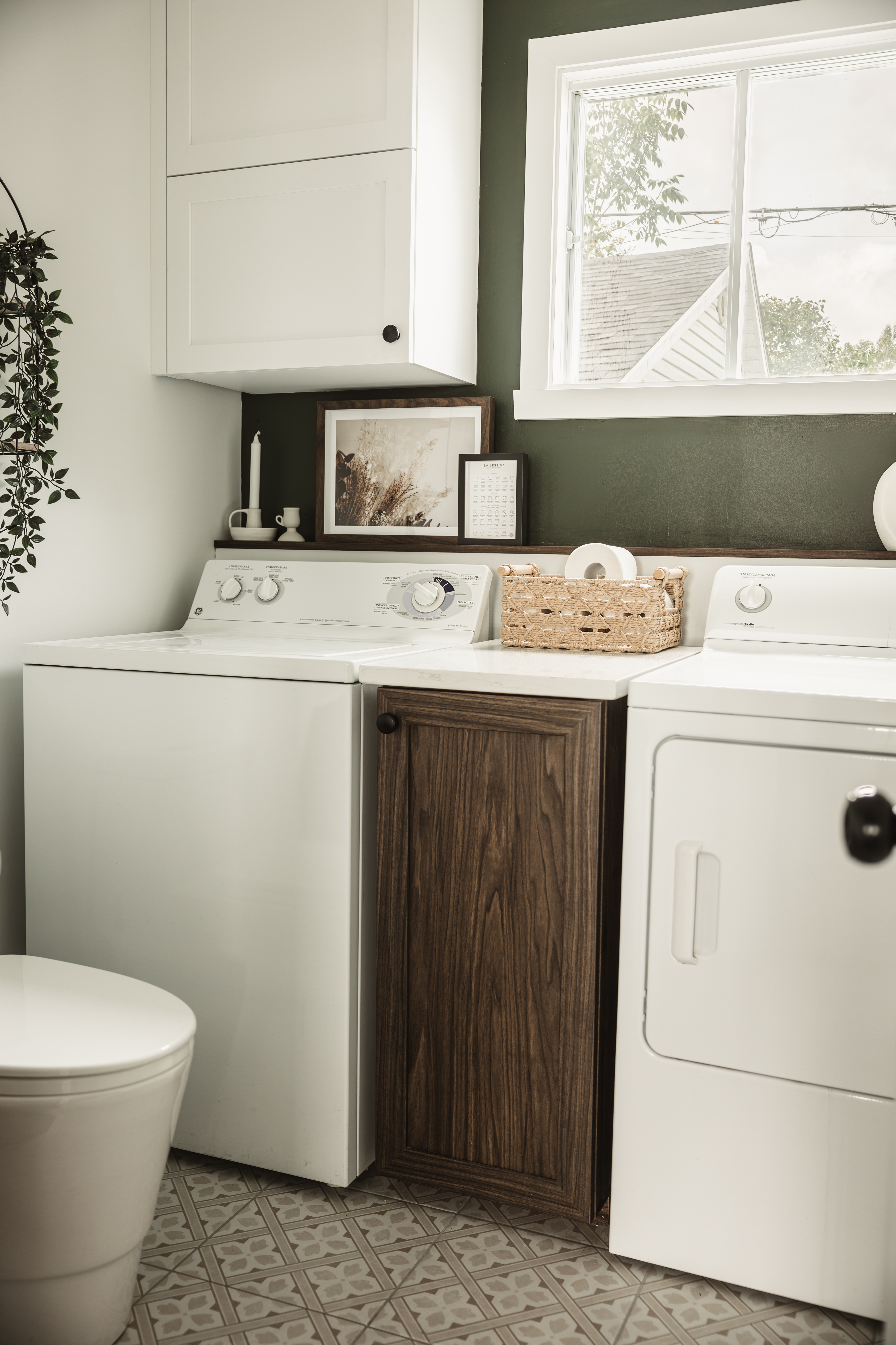 Salle de lavage rénovée avec mur vert, laveuse-sécheuse et vanité effet bois foncé | salle d'eau et de lavage au rez-de-chaussée | designer d'intérieur, Élévation Studio Design à Thetford Mines