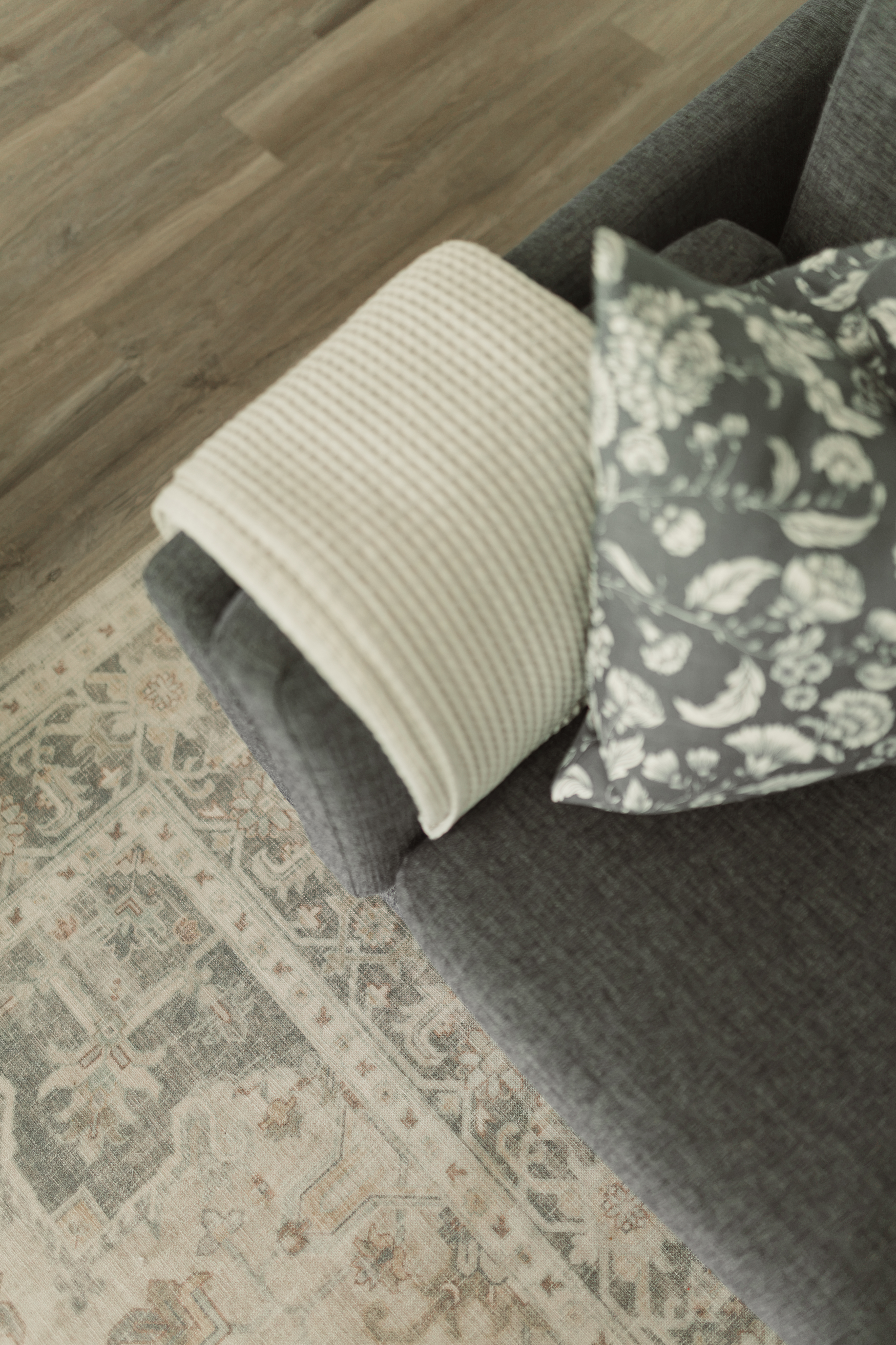 Détail d'un divan bleu avec tapis, jeté et coussin décoratif pour un salon confortable et invitant | designer d'intérieur en Chaudière-Appalaches